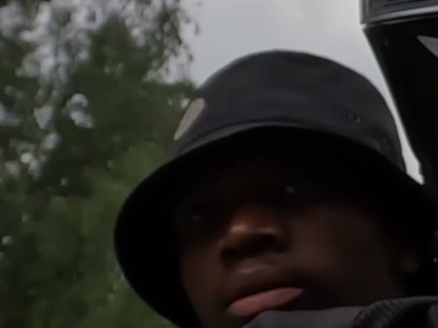 Mc-förare i solhatt tittar bakåt över axeln, bildruta ur Goated Poesi